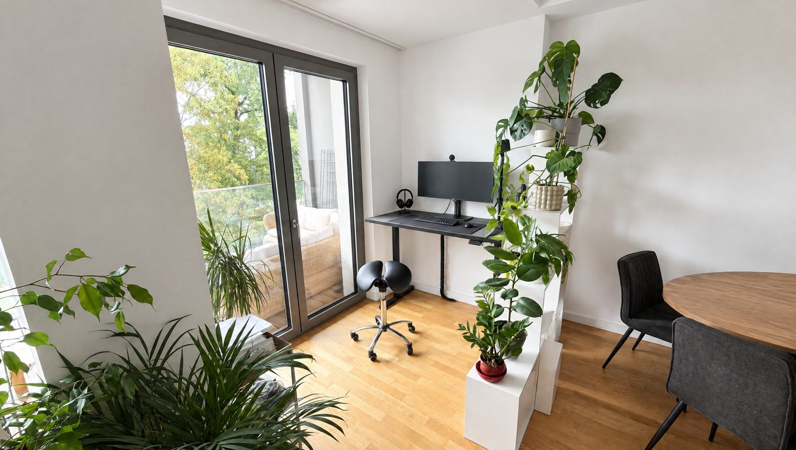 Höhenverstellbarer Schreibtisch mit Monitor am Fenster