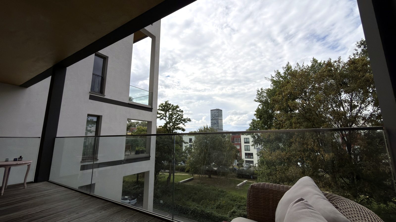 Blick vom Balkon über Bäume auf die Skyline